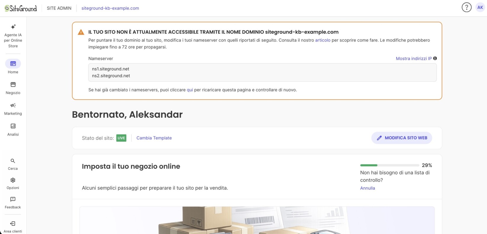 Pagina Home del Site Admin di SiteGround con un banner di avviso arancione: «Il tuo sito non è attualmente accessibile tramite il nome dominio siteground-kb-example.com», con i nameserver ns1.siteground.net e ns2.siteground.net. Sotto, «Bentornato, Aleksandar», Stato del sito LIVE e la lista di configurazione del negozio al 29 %.